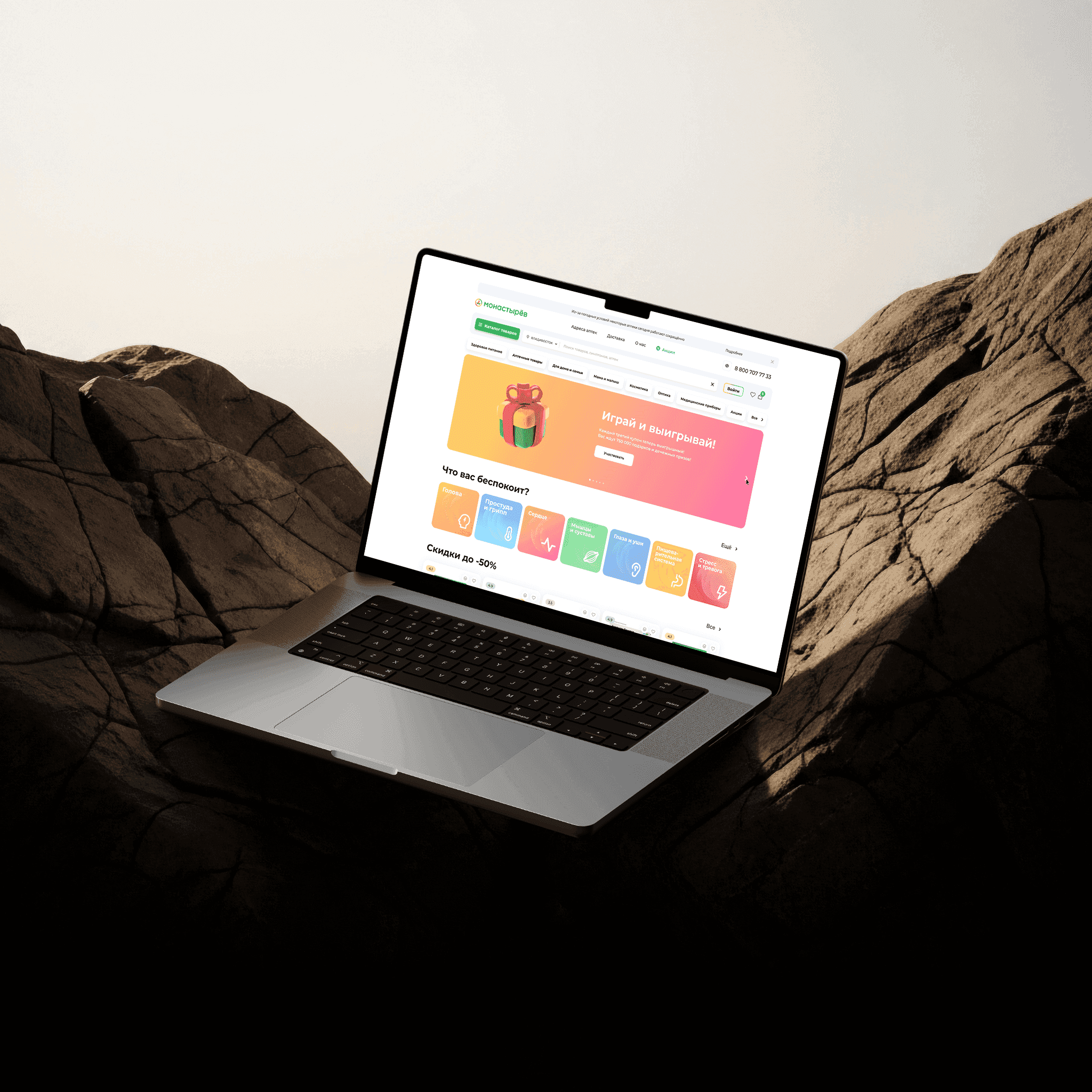The Monastirev pharmacy home page on a laptop: a promotions banner above a “What is troubling you?” row of symptom categories — head, cold and flu, heart, muscles and joints, eyes and ears, digestion, stress.