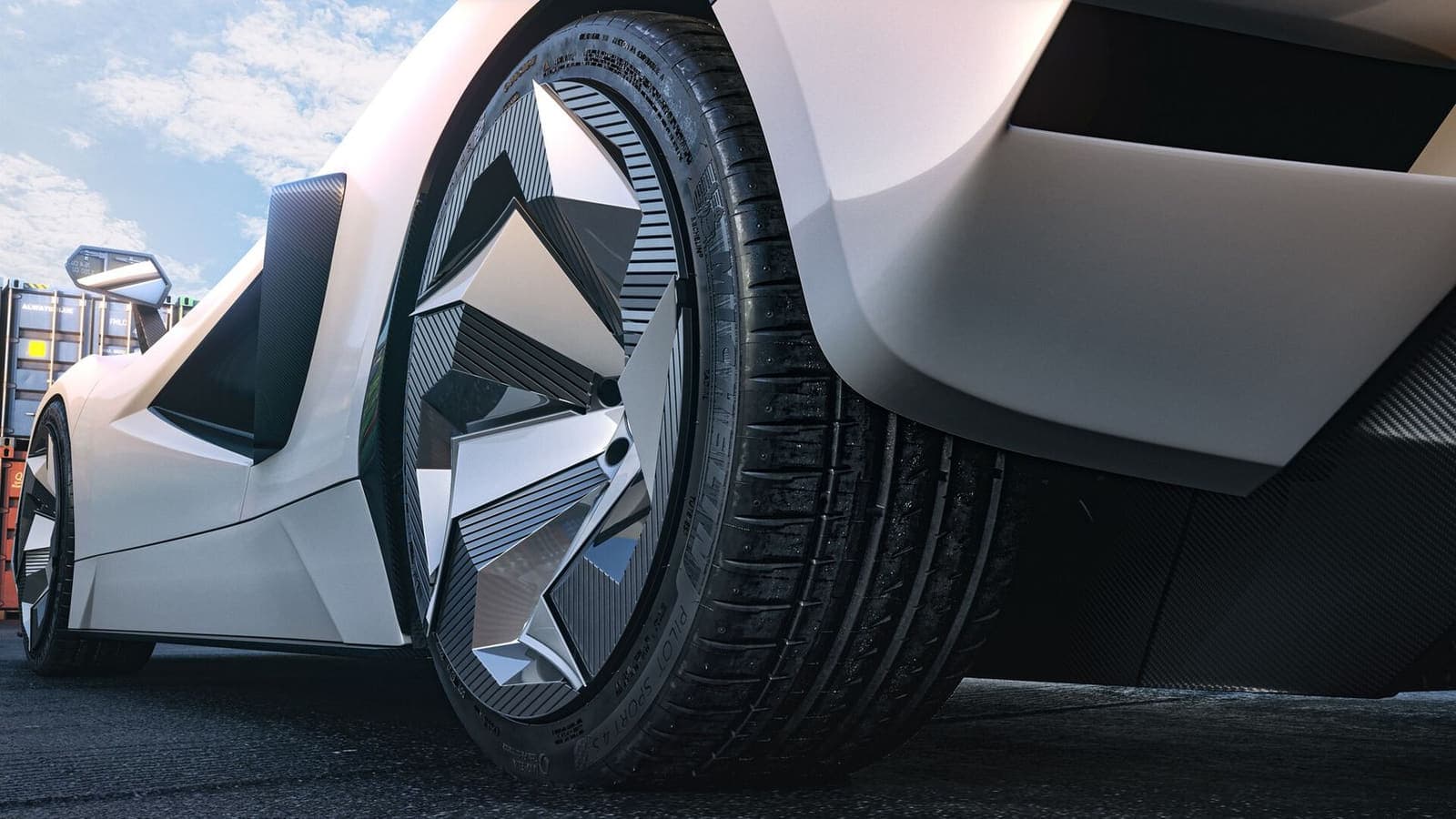A close view of a wheel on a white car: five spokes folded into flat facets, each face catching the light at a different angle, over a finely ribbed dark field filling the barrel behind them.